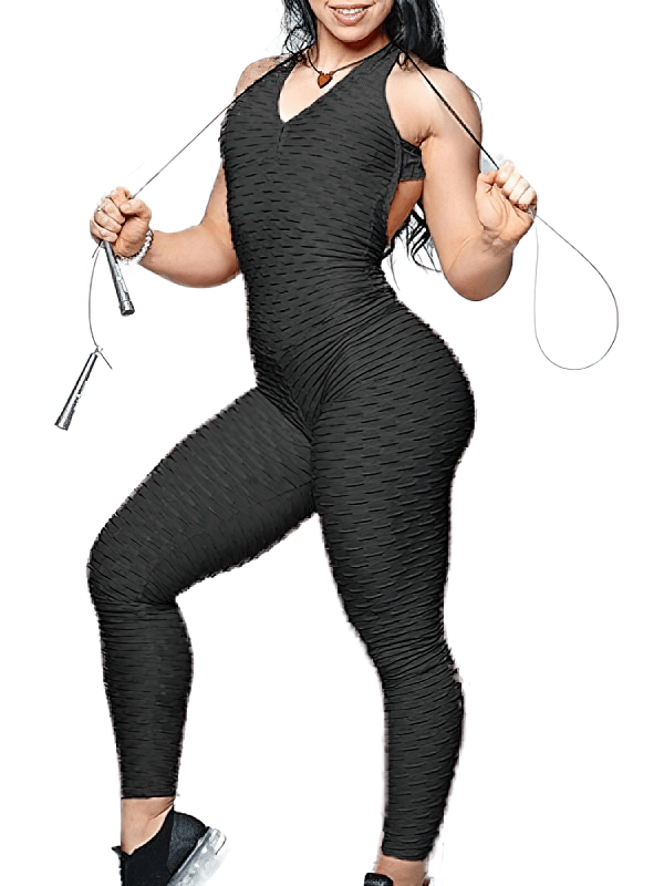Woman wearing black textured open-back yoga jumpsuit and holding a jump rope, showcasing breathable, lightweight design.